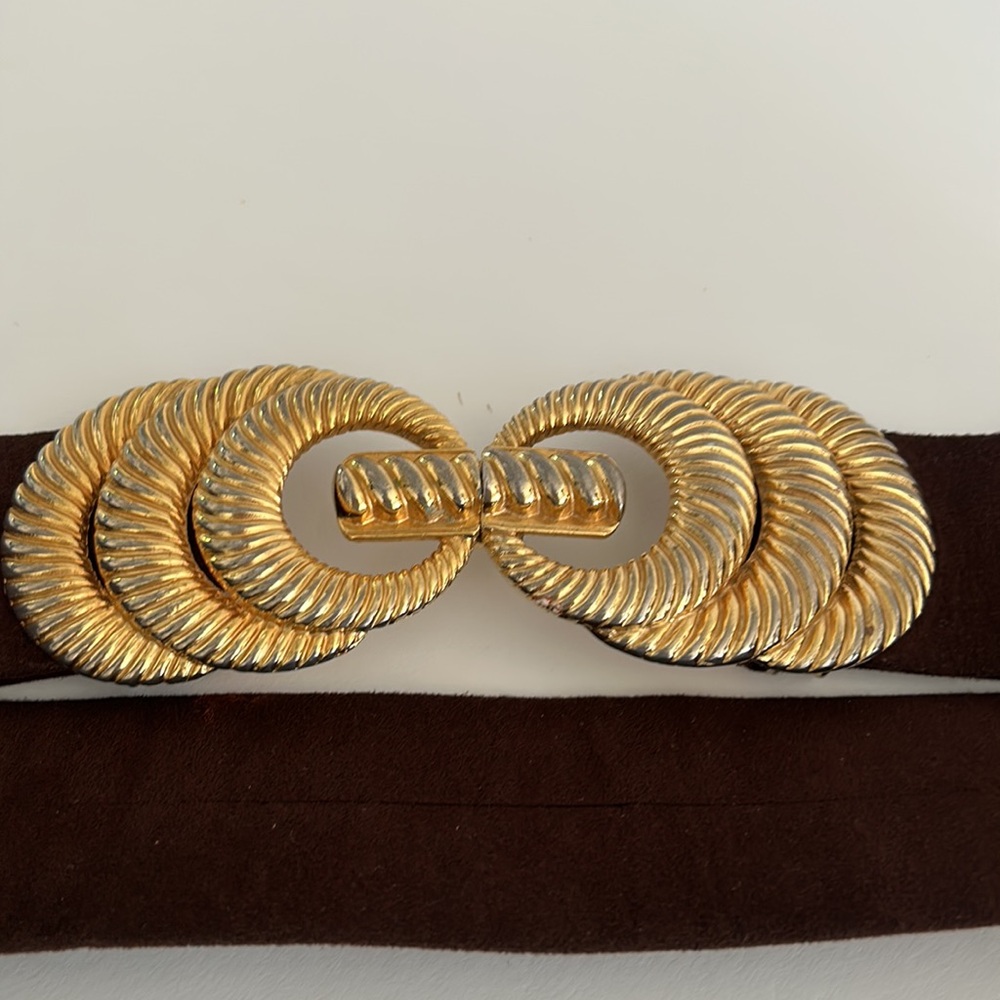 Brown strap belt with artistic gold metal buckle.